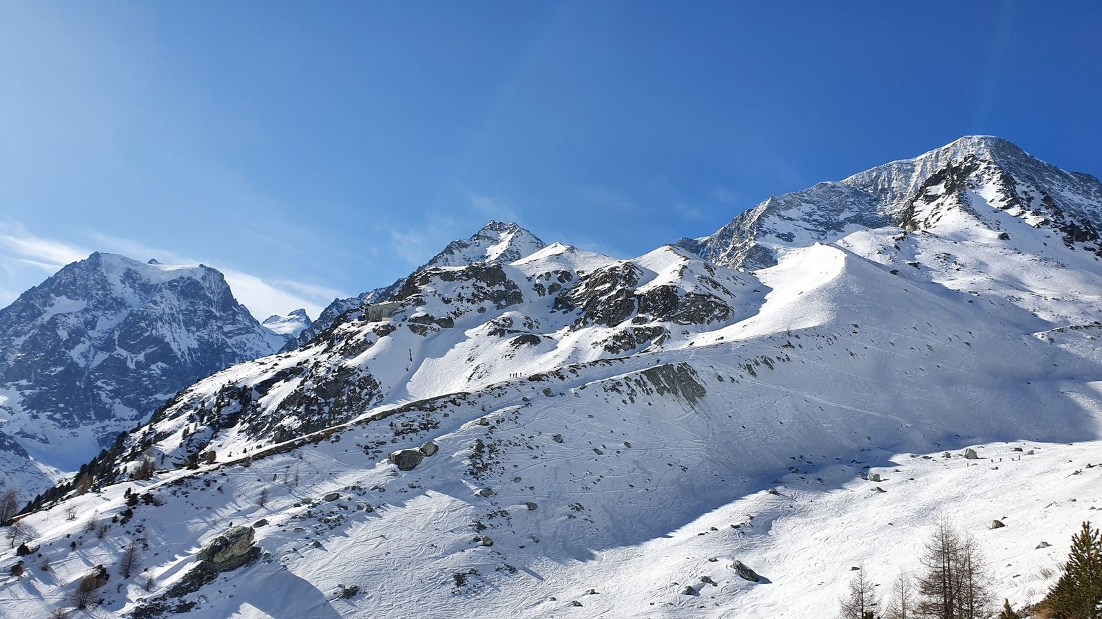 20 Arolla Pas de Chèvres: stopy v teréne vedľa zjazdovky smerujú k Pigne d'Arolla (vpravo)